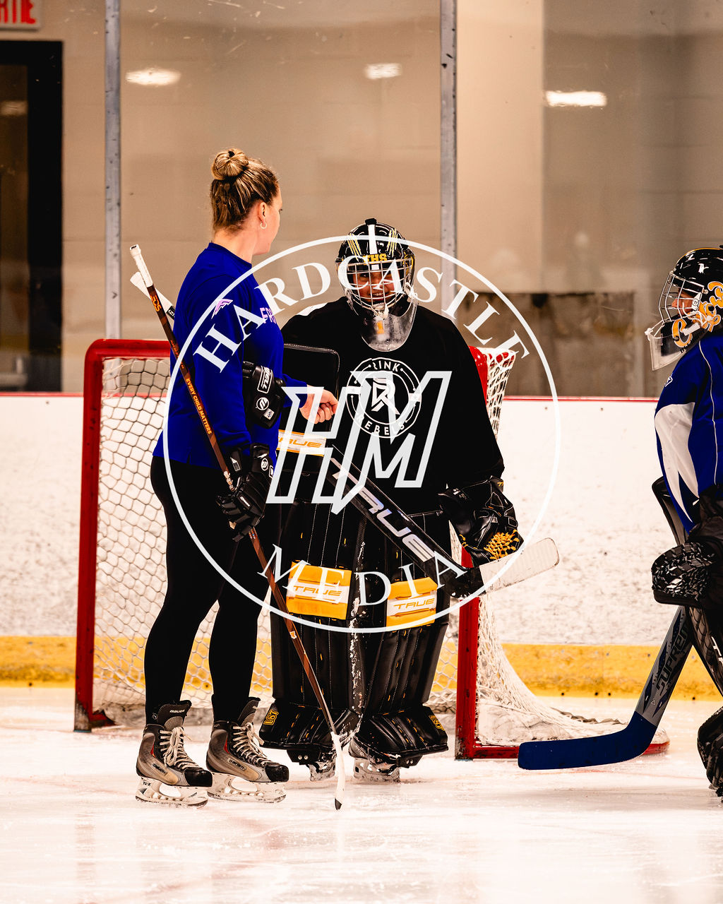 An athlete mentor speaking with a young goalie